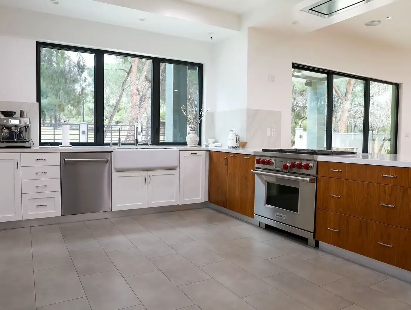 Modern kitchen with large windows, white and wood cabinetry
