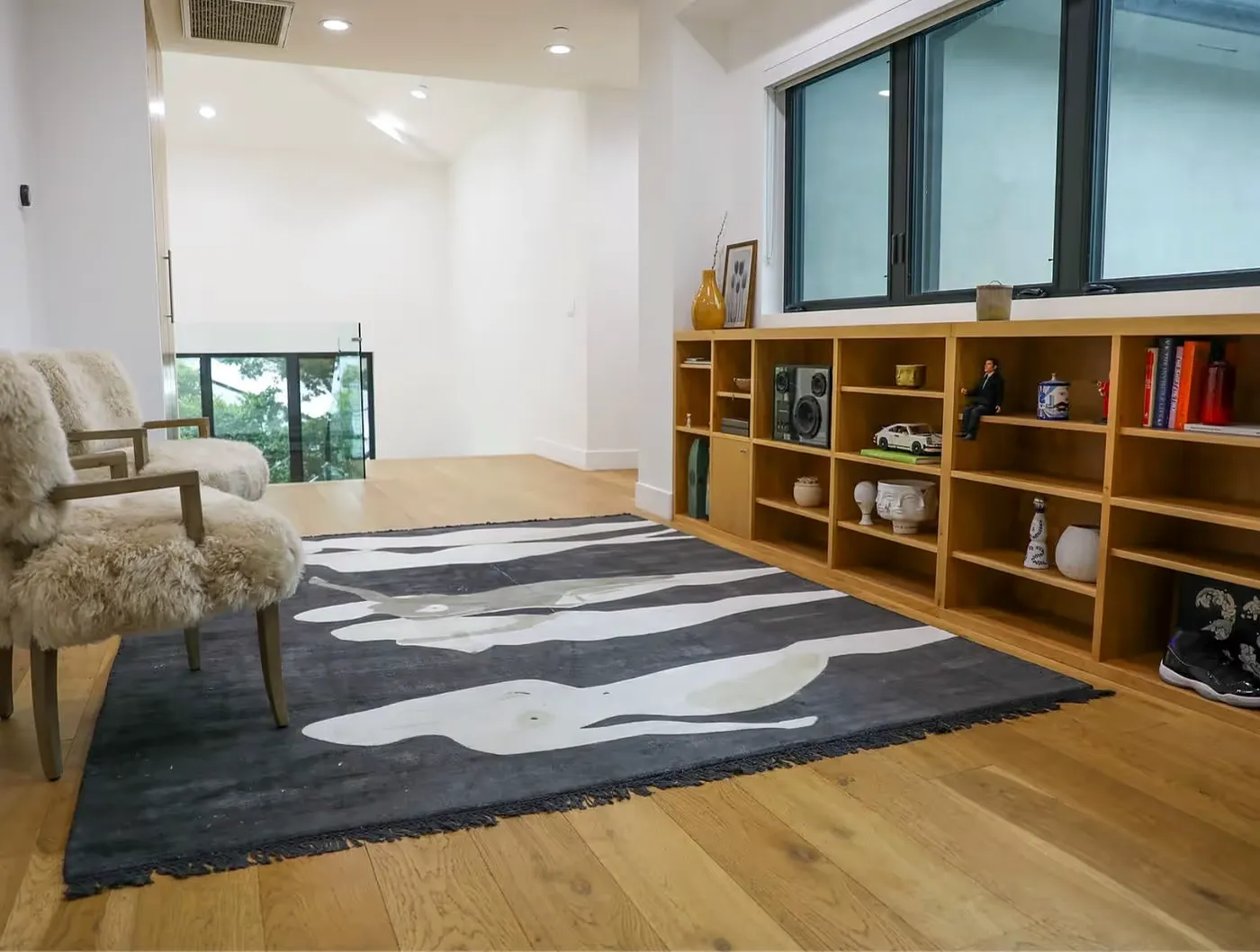 Modern room with fur-covered chairs and patterned black and white rug