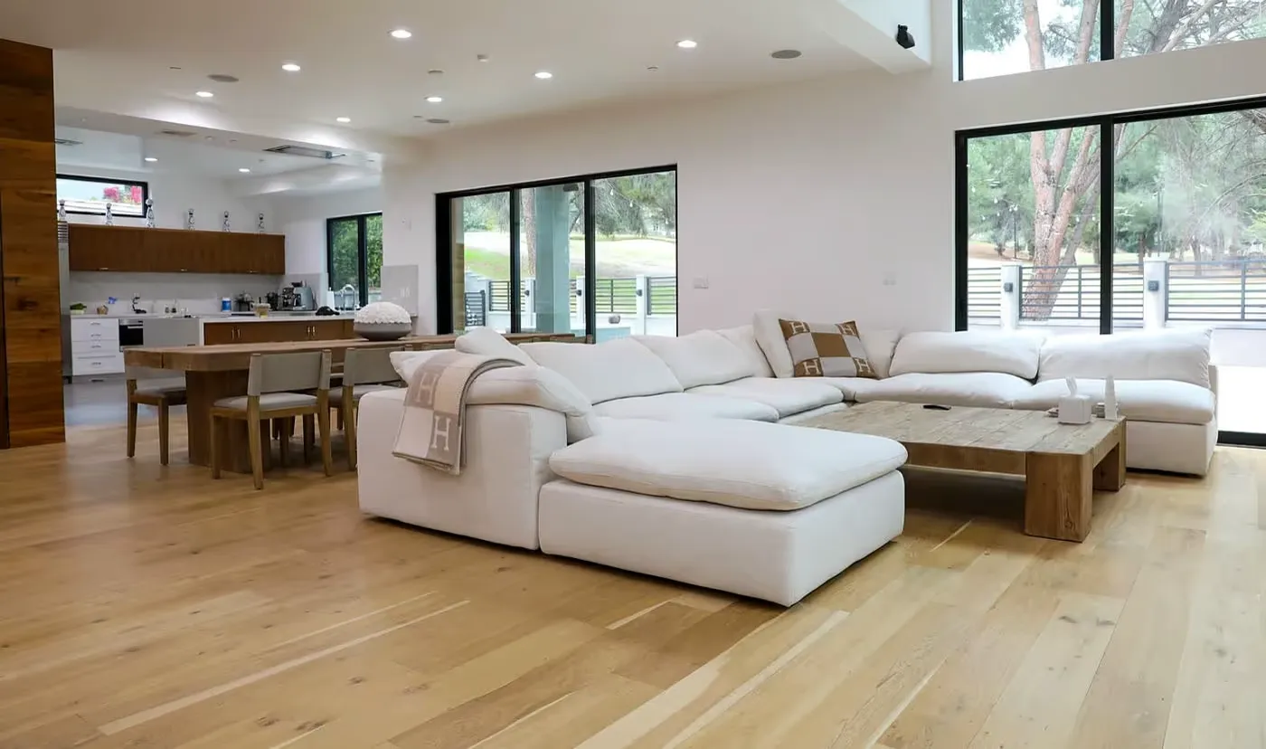 Modern living room with large white sectional sofa and wood accents