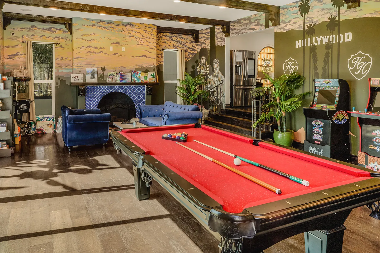 Games room with a red pool table, painted landscape murals and blue velvet seating