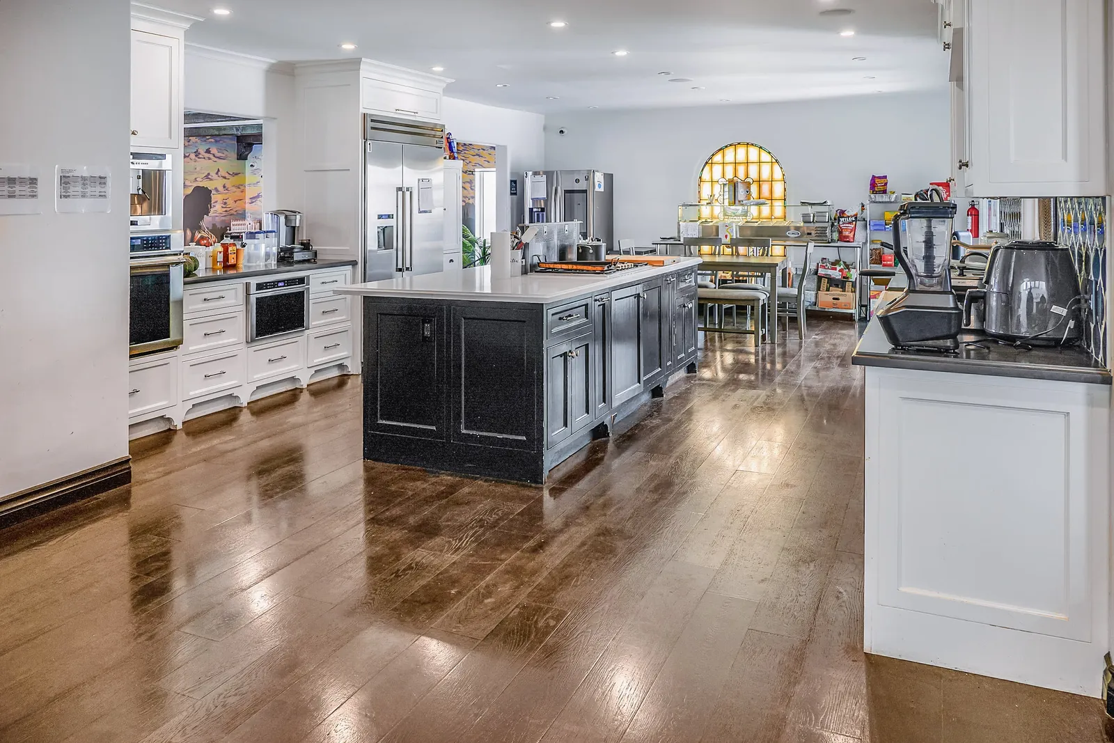 Long kitchen with two islands and dark wood floors