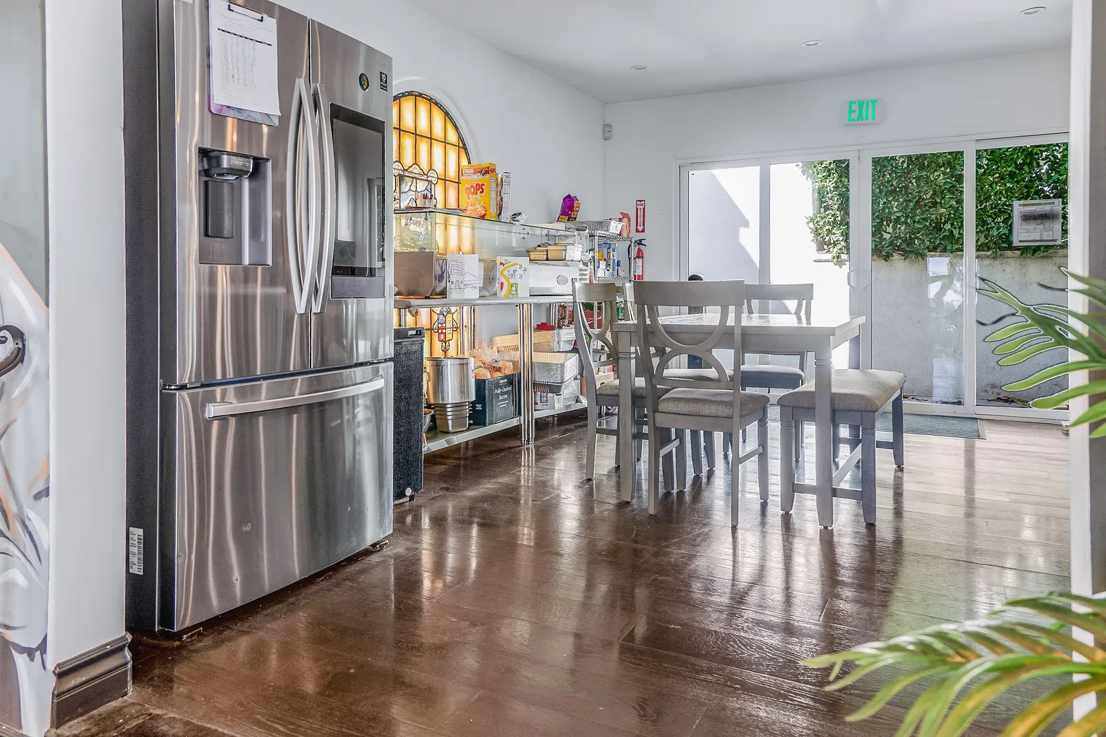 Kitchen and dining area with a stainless steel refrigerator and an arched window