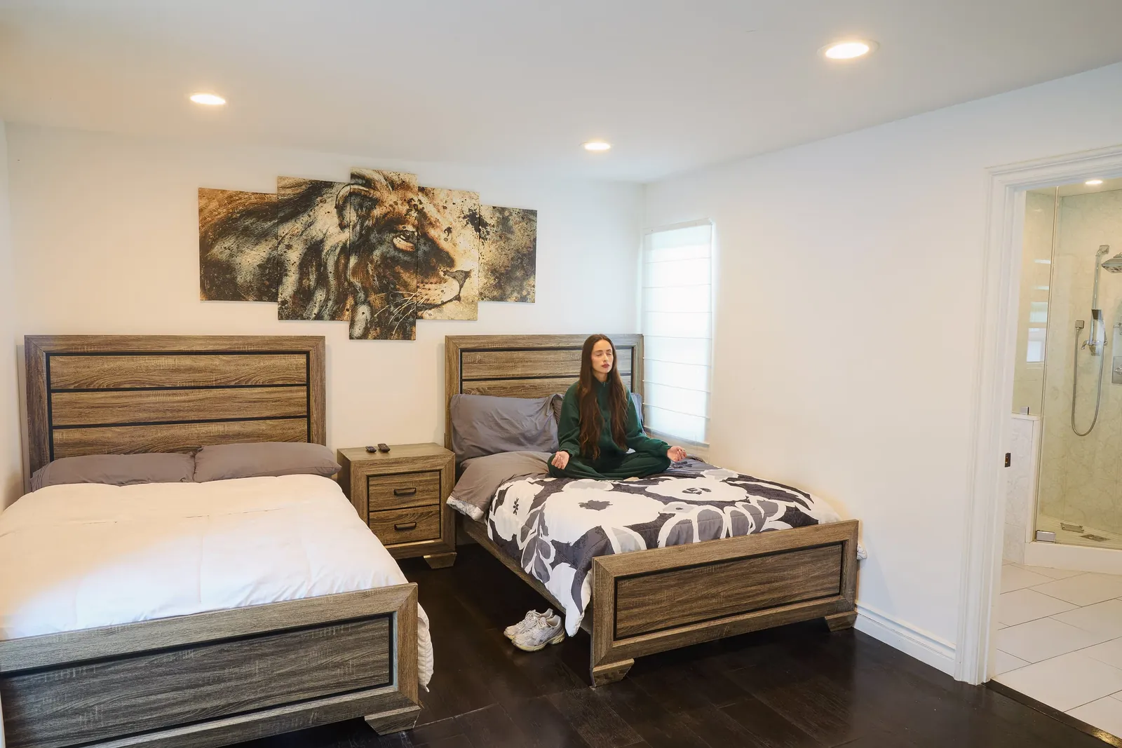Twin bedroom with wooden bed frames and an en-suite bathroom beyond